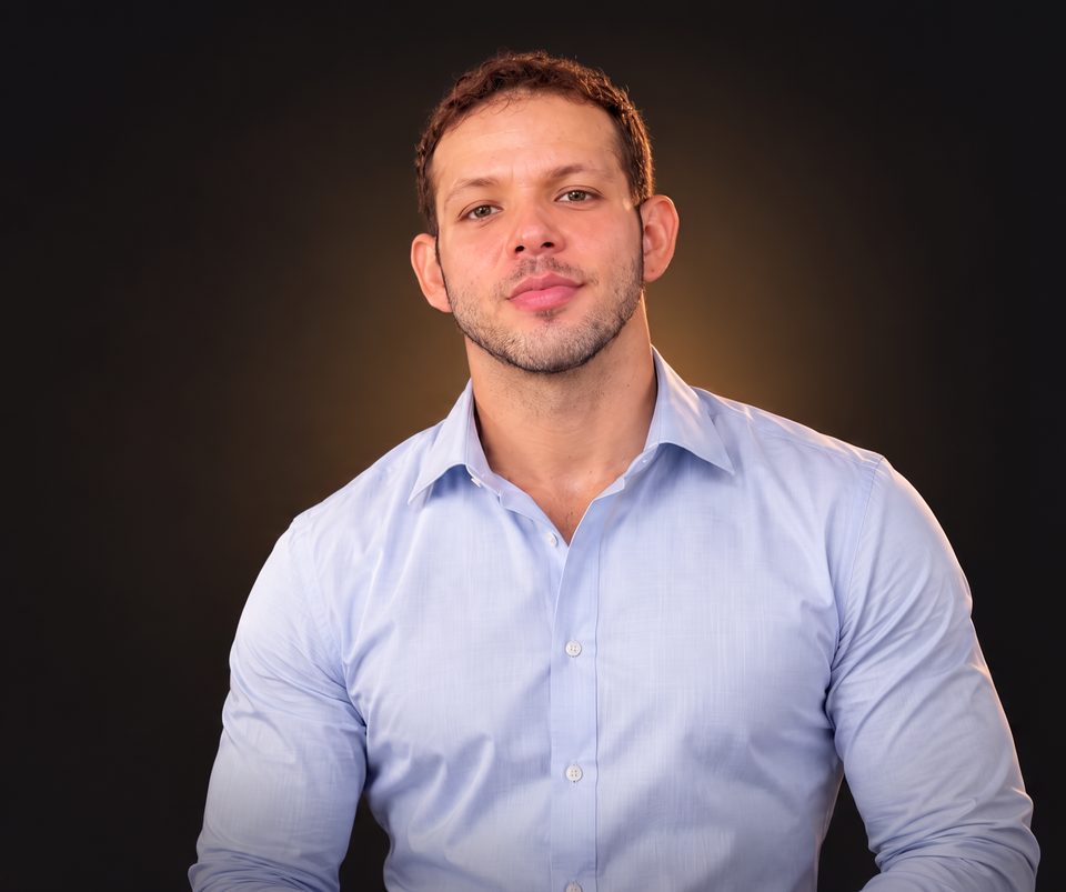 José Paulo Ferreira, nutricionista, de camisa social azul-clara, em estúdio com fundo escuro